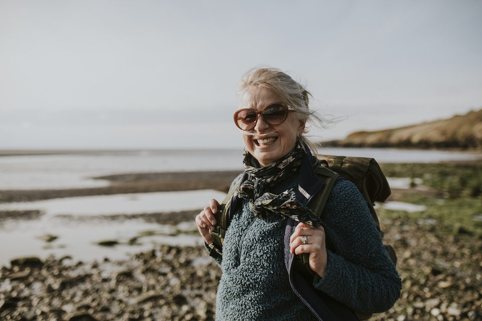 Senior tourist woman walking at the beach