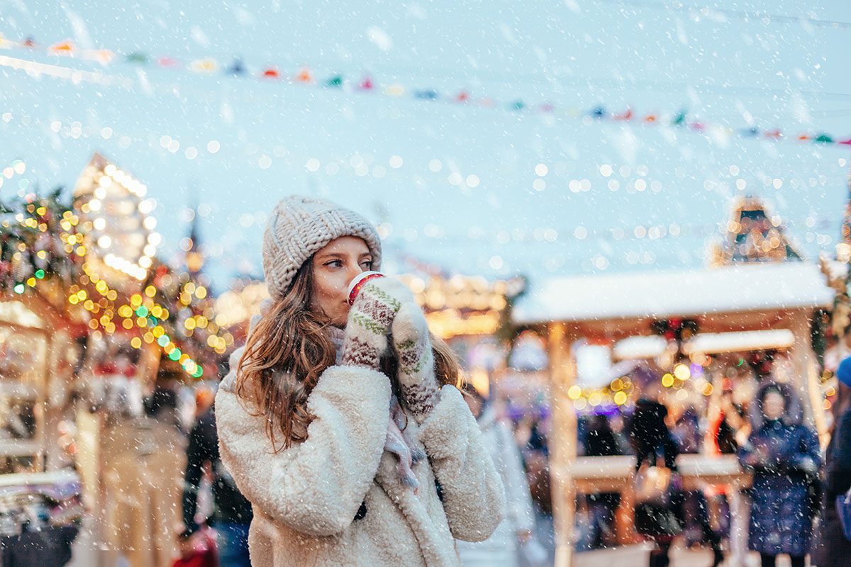 Woman drinking hot coffee at Christmas market