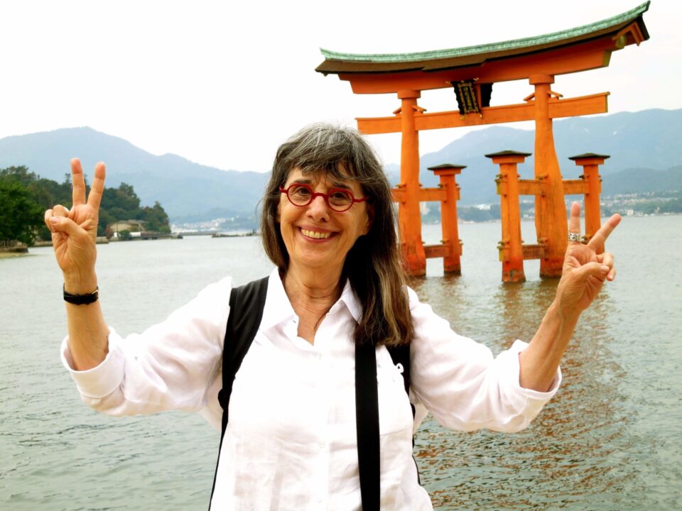 woman standing near floating gate in Japan, one of the top places for solo travel in 2023