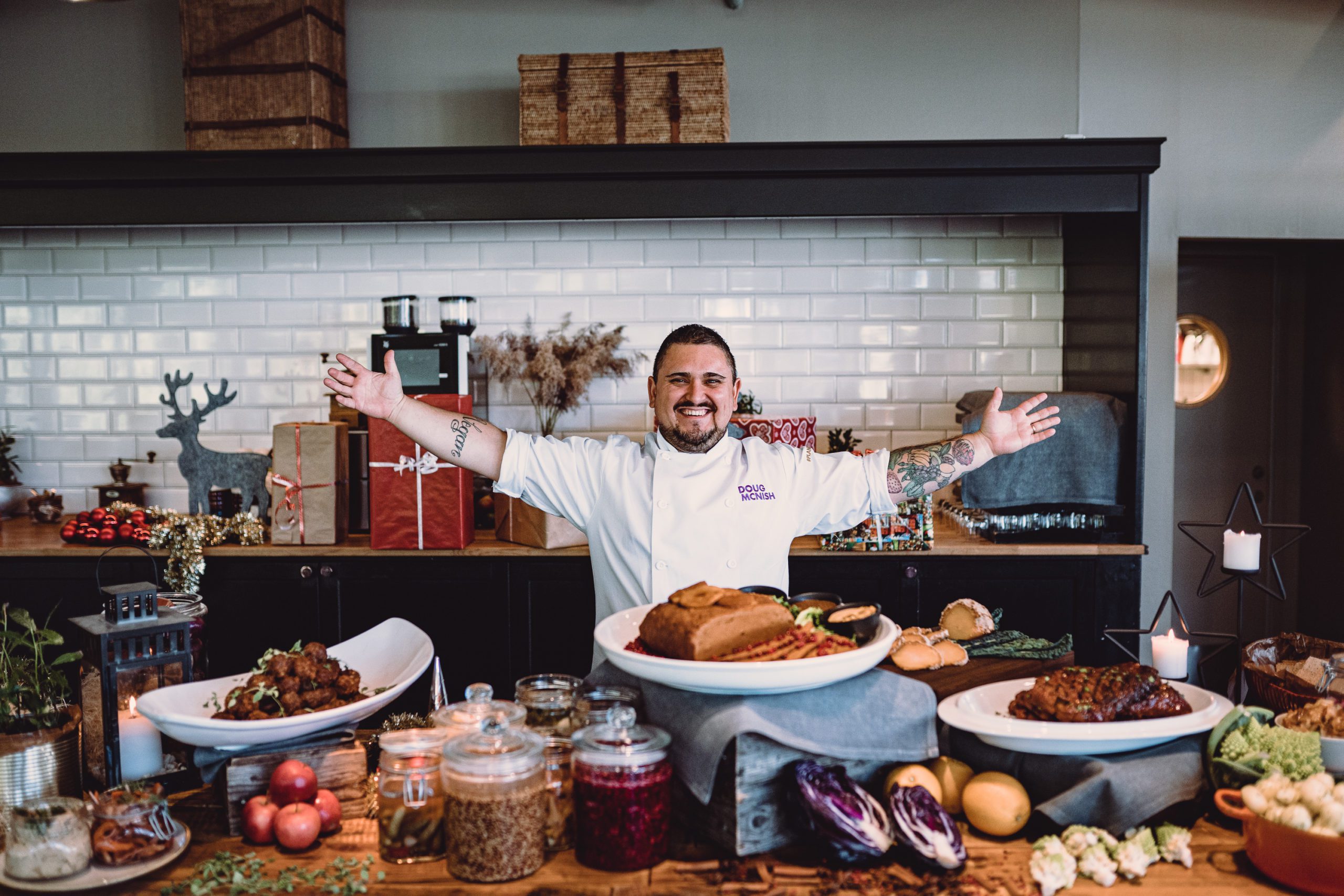 Chef Doug Mcnish stands over a julboard spread