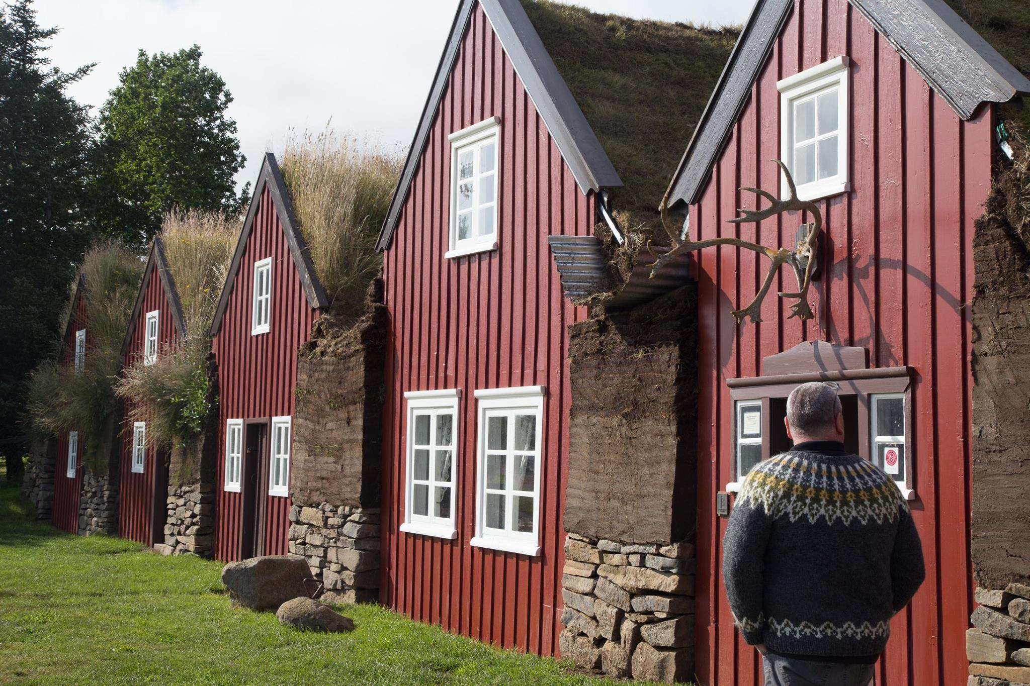 A woman standing in front of a row of red houses in Iceland