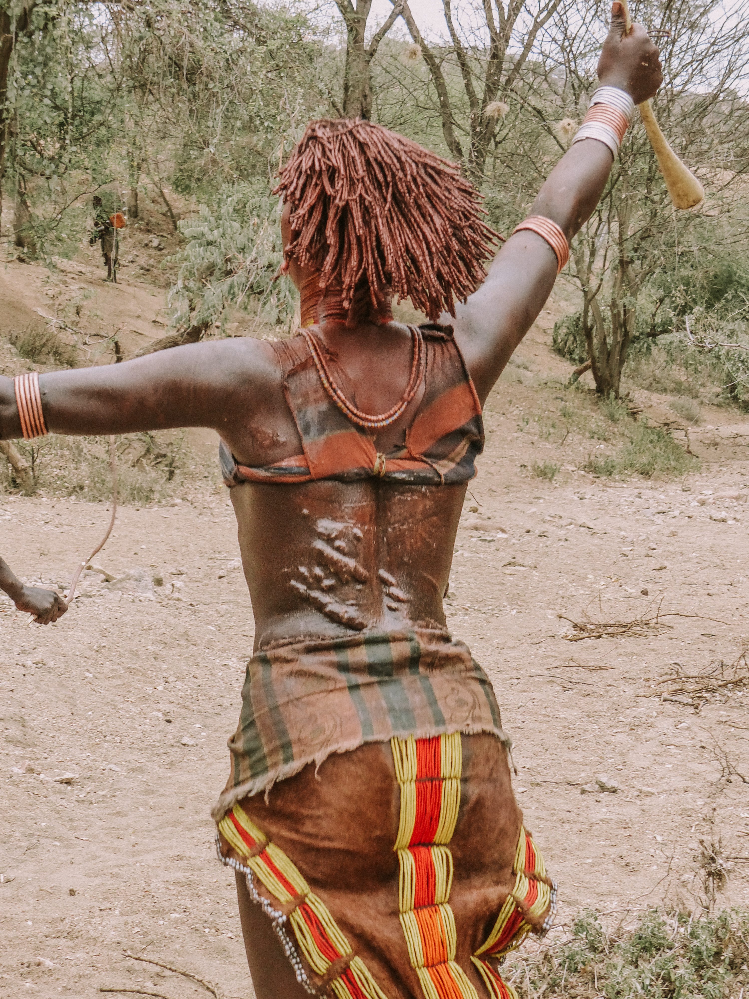 Woman of the Hamer tribe dancing after being ceremonially whipped