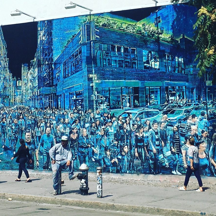 Blue mural with man standing in front