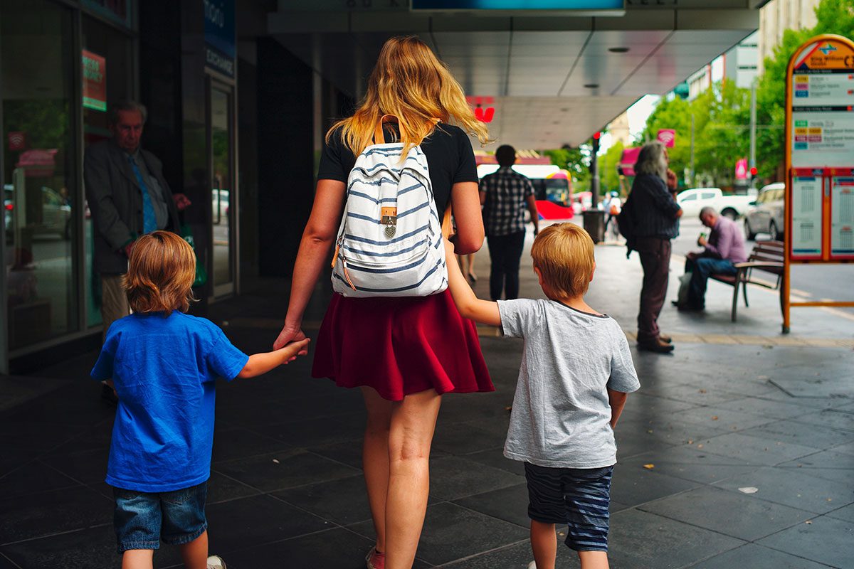 Woman walking with two kids