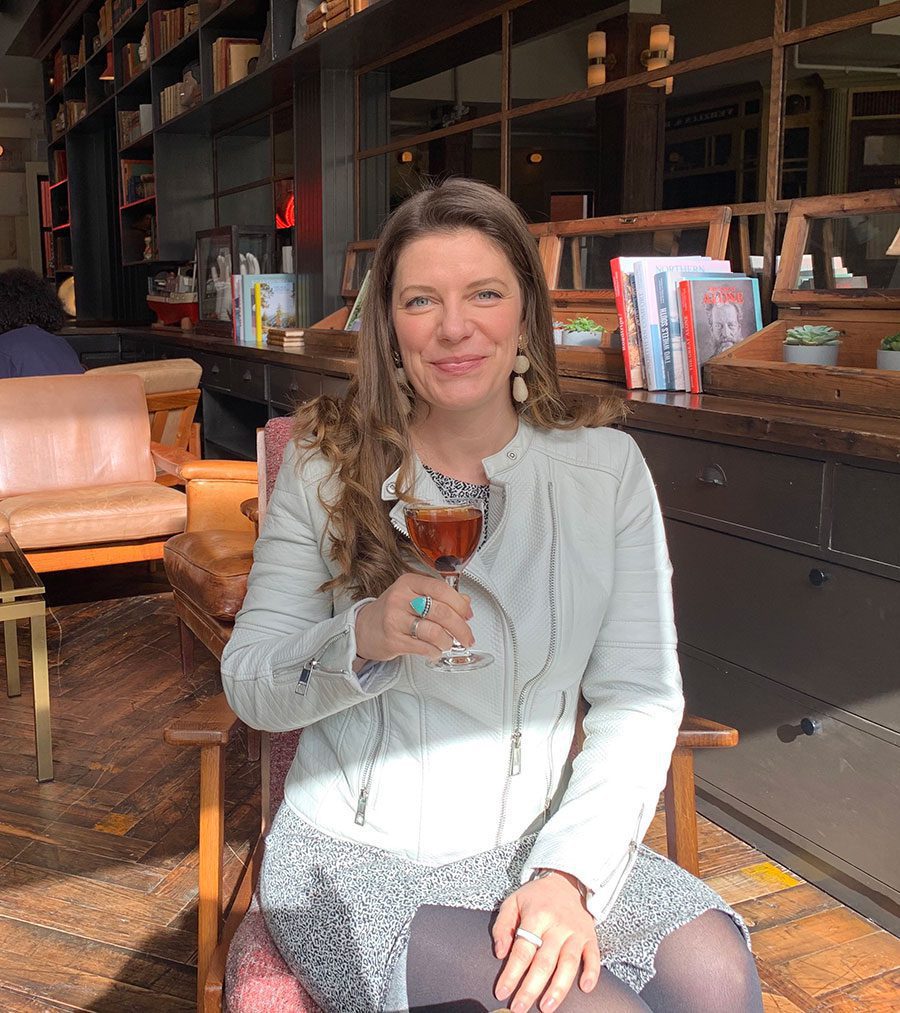 The author with a glass of wine at a bar in Portland