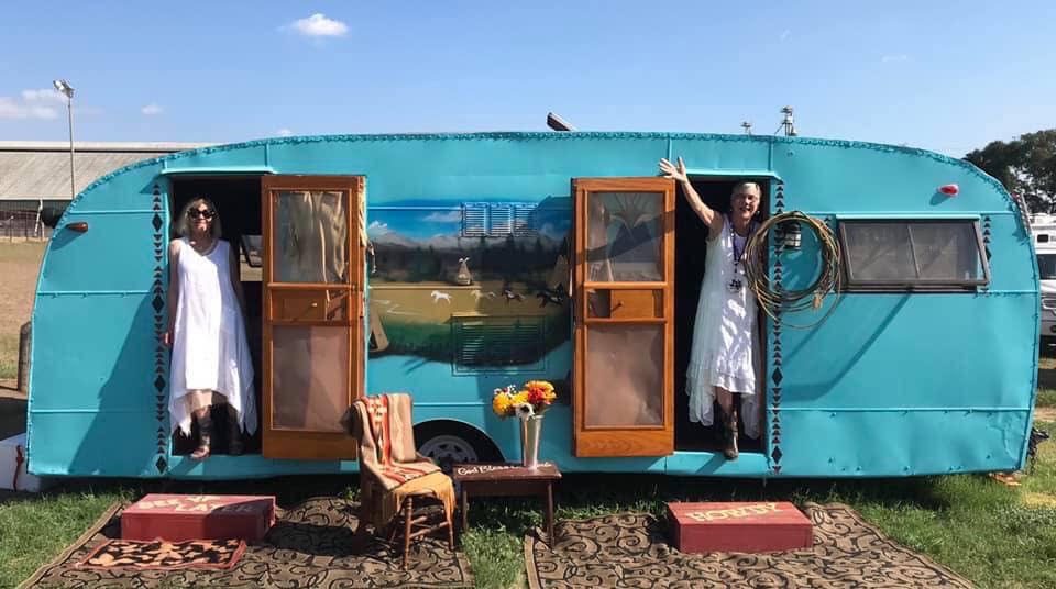 Maurrie Sussman and her sister Becky at each door of a vintage turquoise trailer
