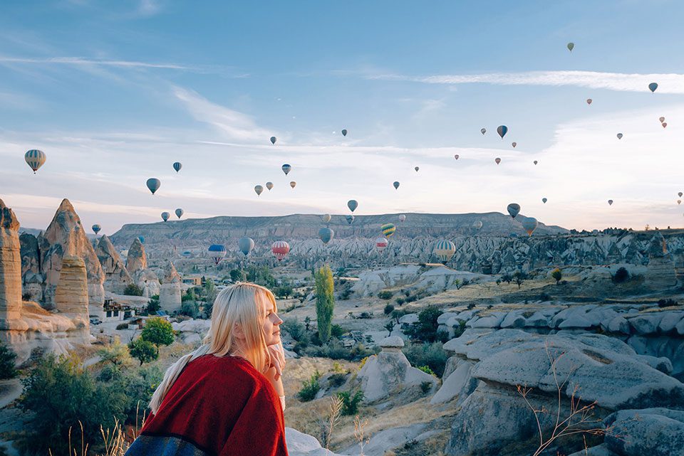 Girl watching baloons in Cappadocia at dawn