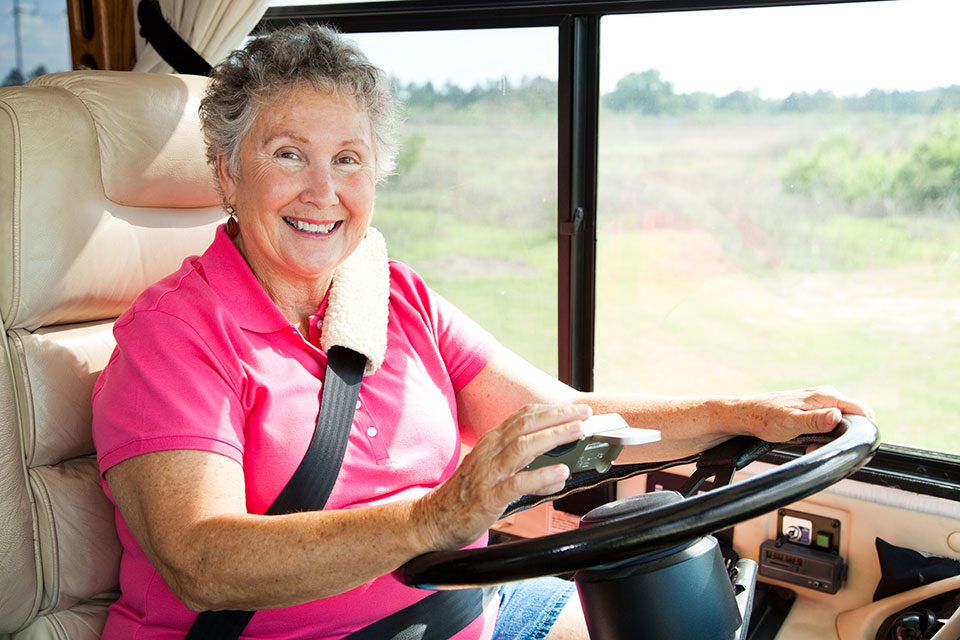 Smiling older woman driving RV