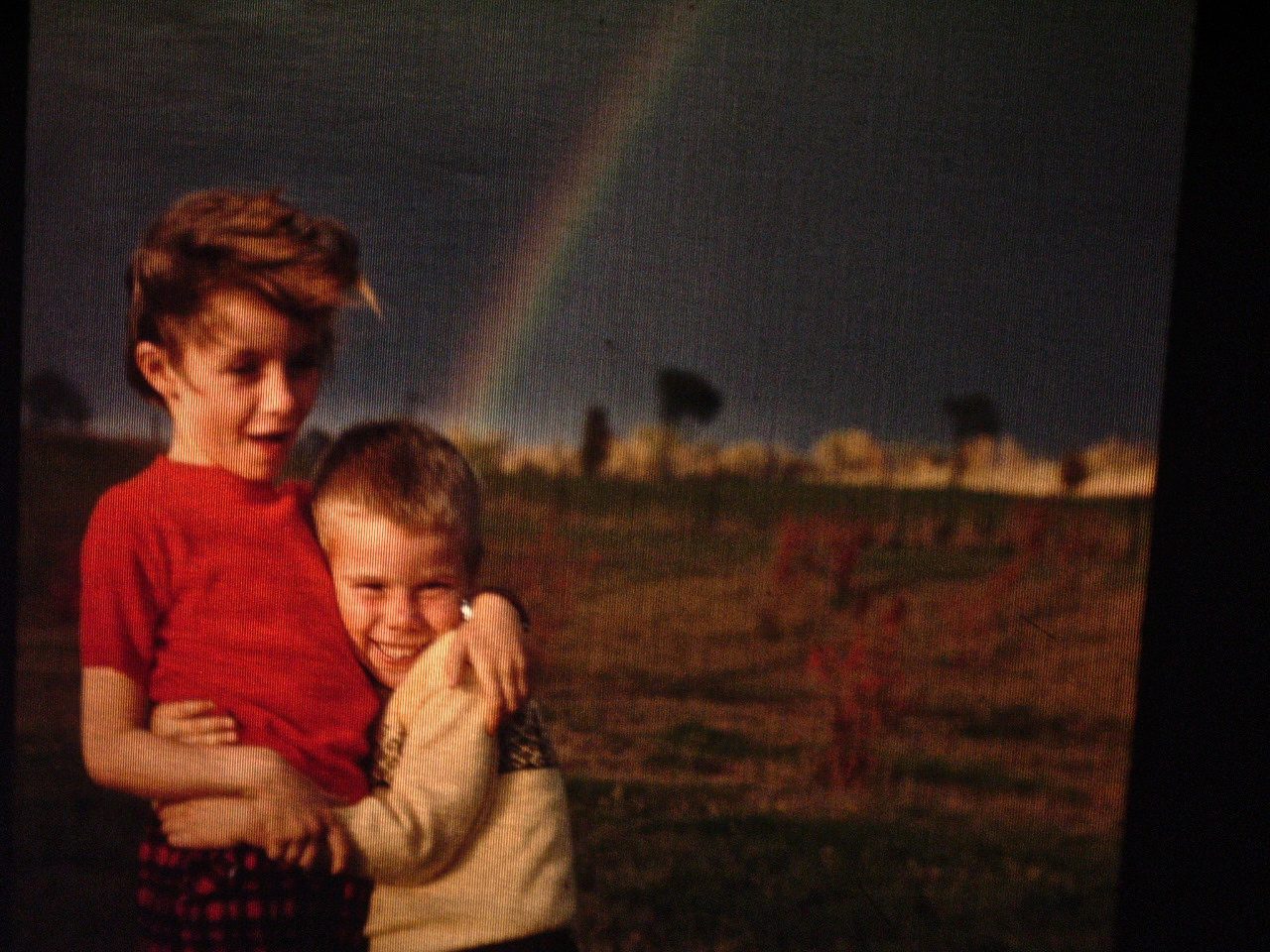 Vintage photo of two children with rainbow in background