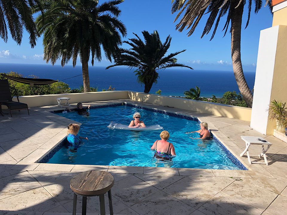 Older women enjoy the pool at a villa