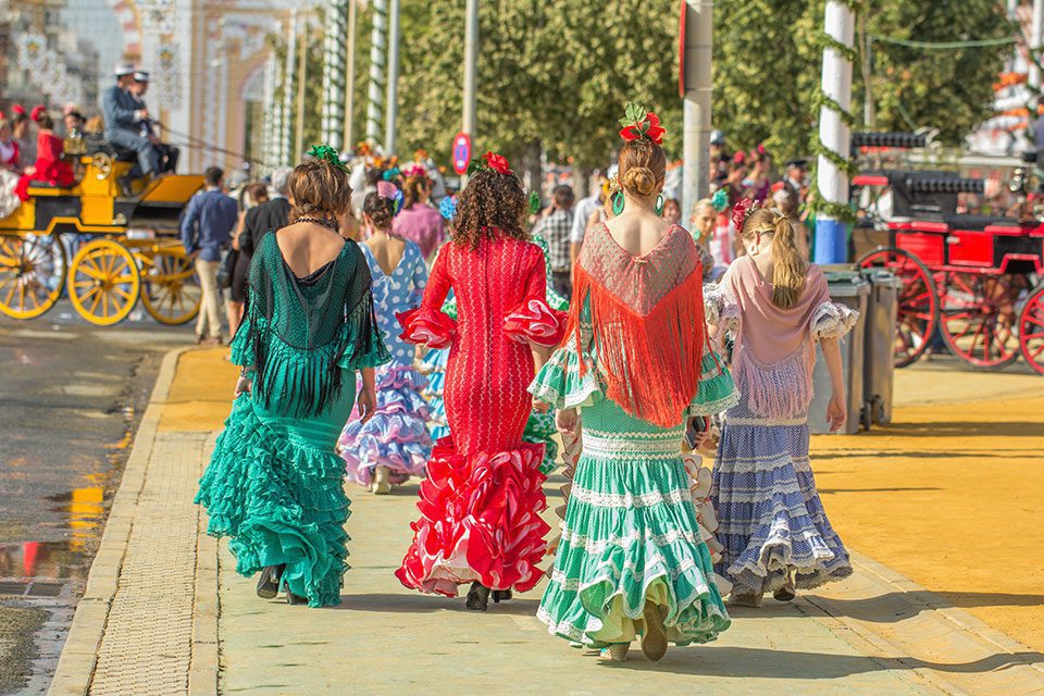 Young women dressed in colourfultraditional dress, Seville, Spain