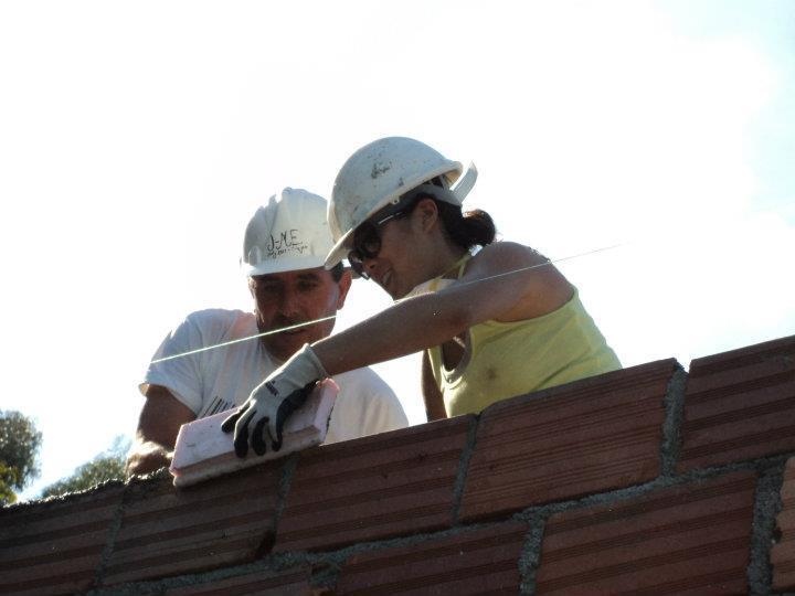 Kristina uses a trowel to lay cement