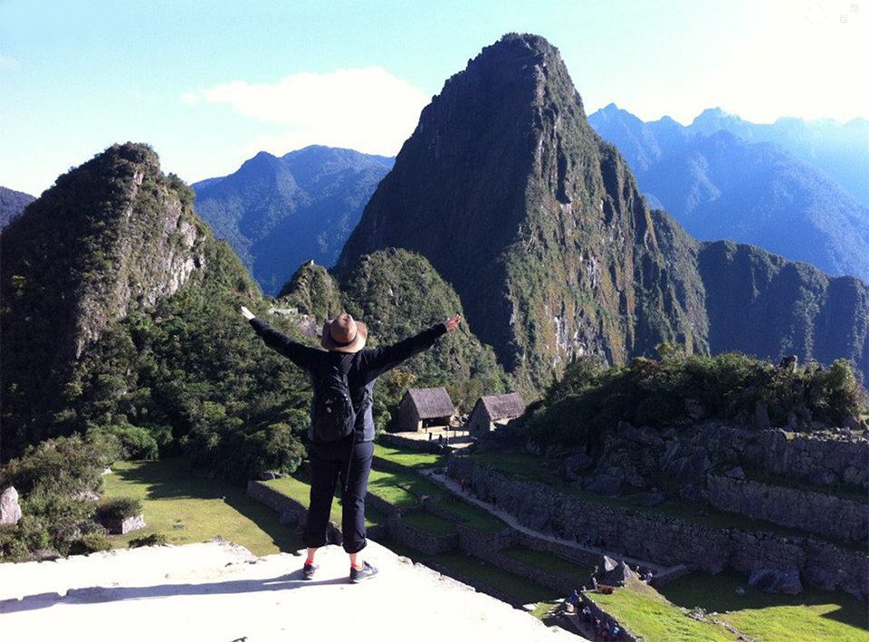 Christine Pope, author, with arms up and mountains in background