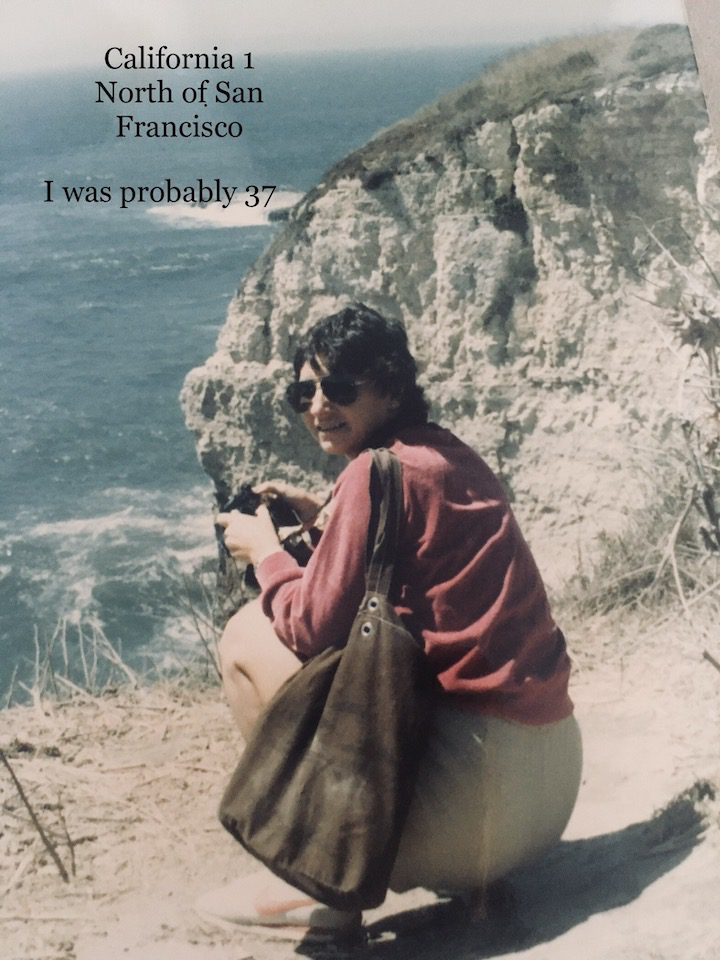 Jane Claud crouching overlooking the cliffs onto the ocean north of San Francisco.