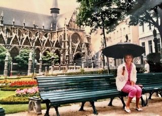 Marille Carroll sitting on a bench holding an open umbrella