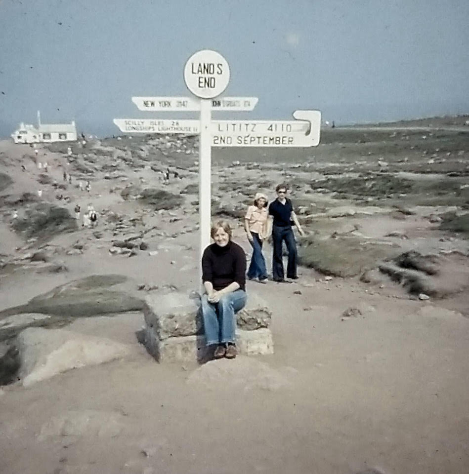 Nancy Chappell, sitting in-front of a sign that says "Land's End"