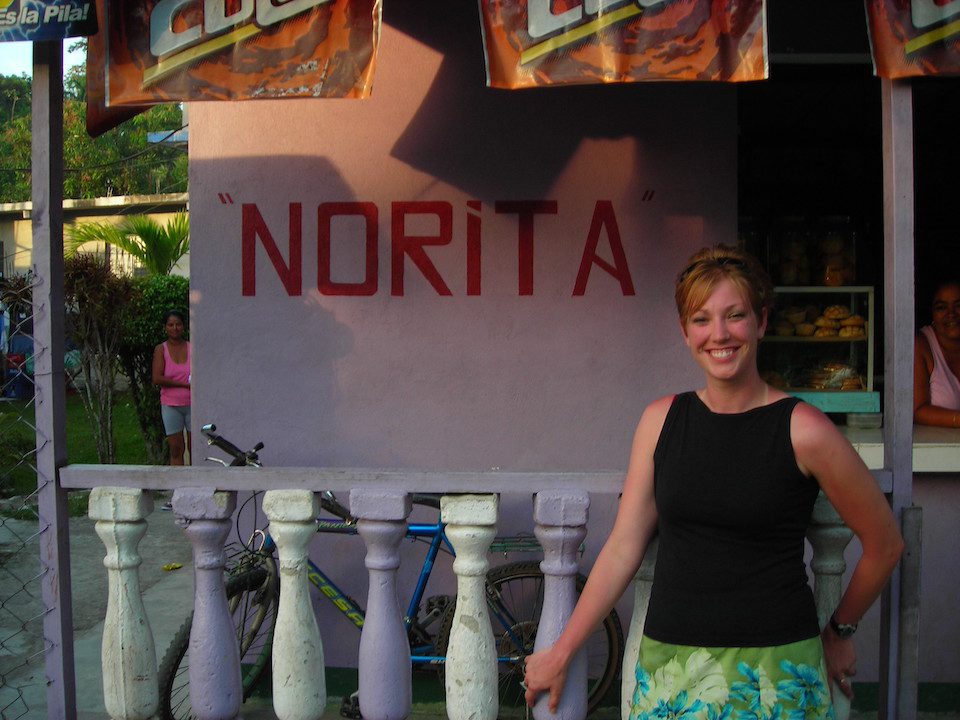 A woman standing infront of a sign that says "Norita"