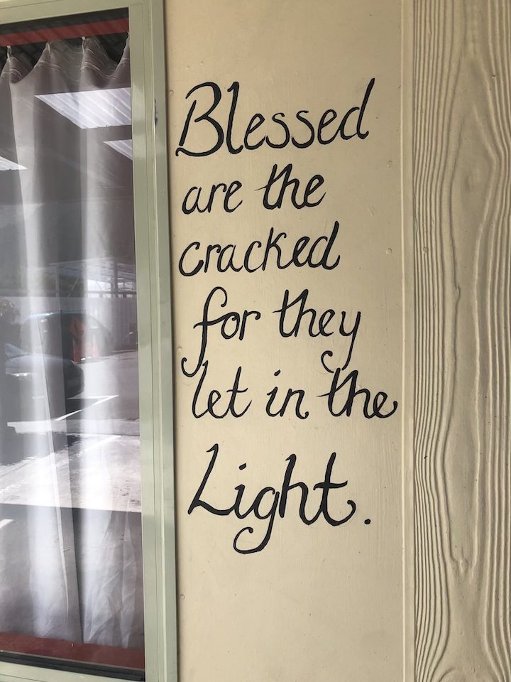 A quote, " blessed are the cracked for they let in the light" painted on a wall in Queenstown