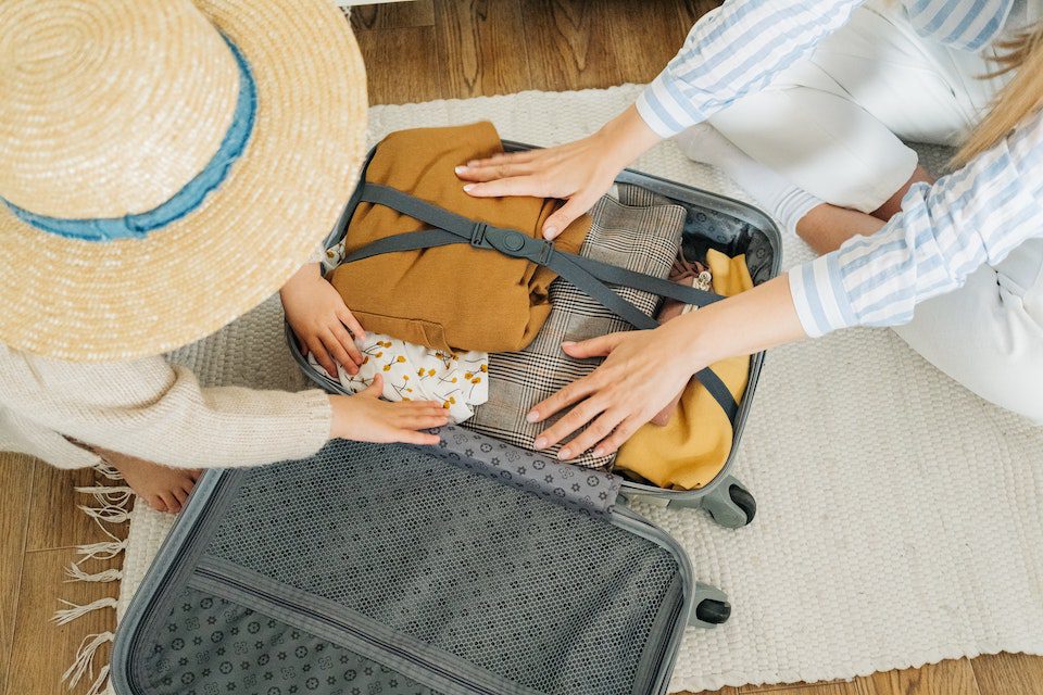 Two woman packing a suitcase after downsizing