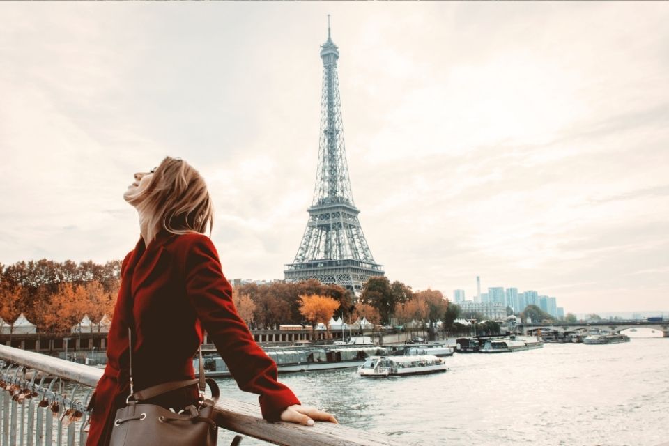 Woman in red jacket in front of Eiffel Tower, Paris, France