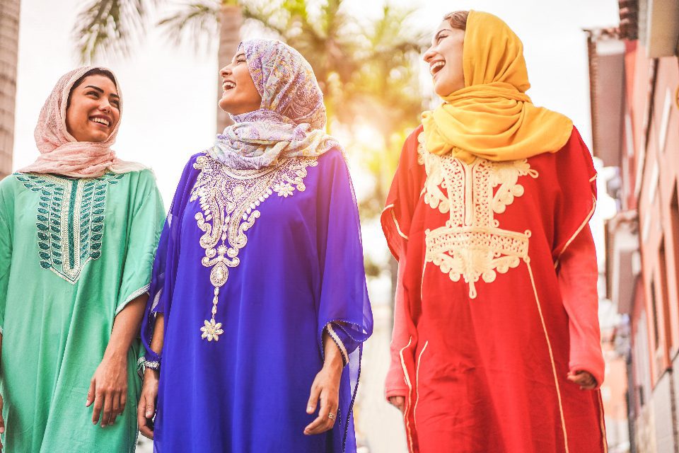Happy Muslim friends walking in Moroccan City - Adobe Stock - DisobeyArt