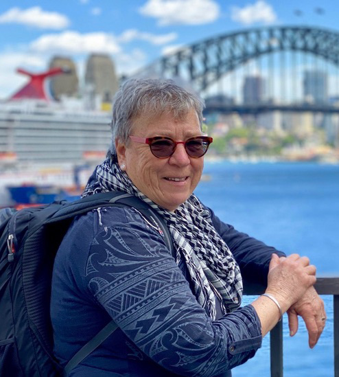 woman in blue coat in front of Sydney Harbour Bridge