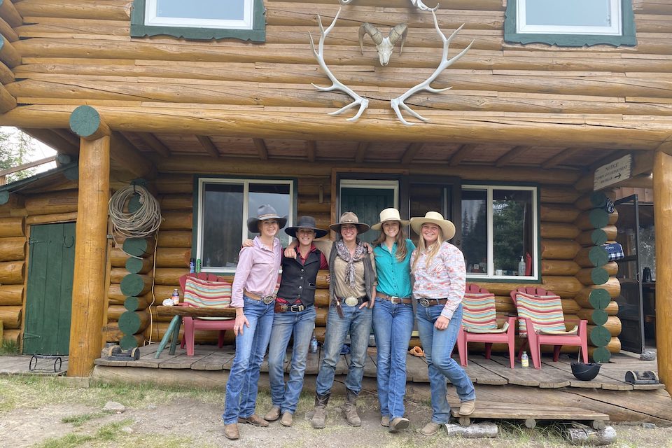 A group of women standing in front of a stable in Banff