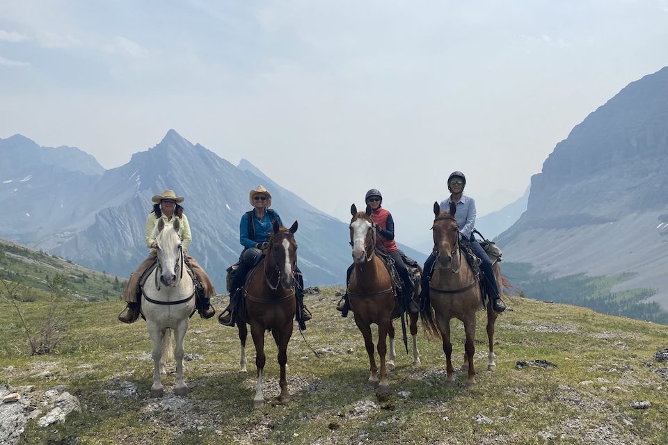 Four women sit on horseback while discovering the real Canadian Rockies