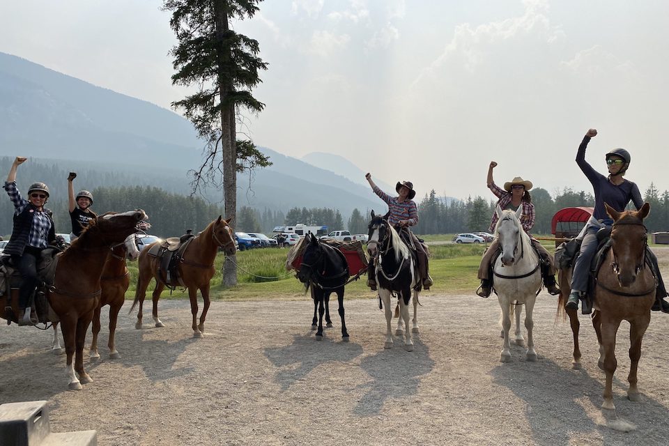 Women sitting on horseback celebrating the end of their backcountry adventure