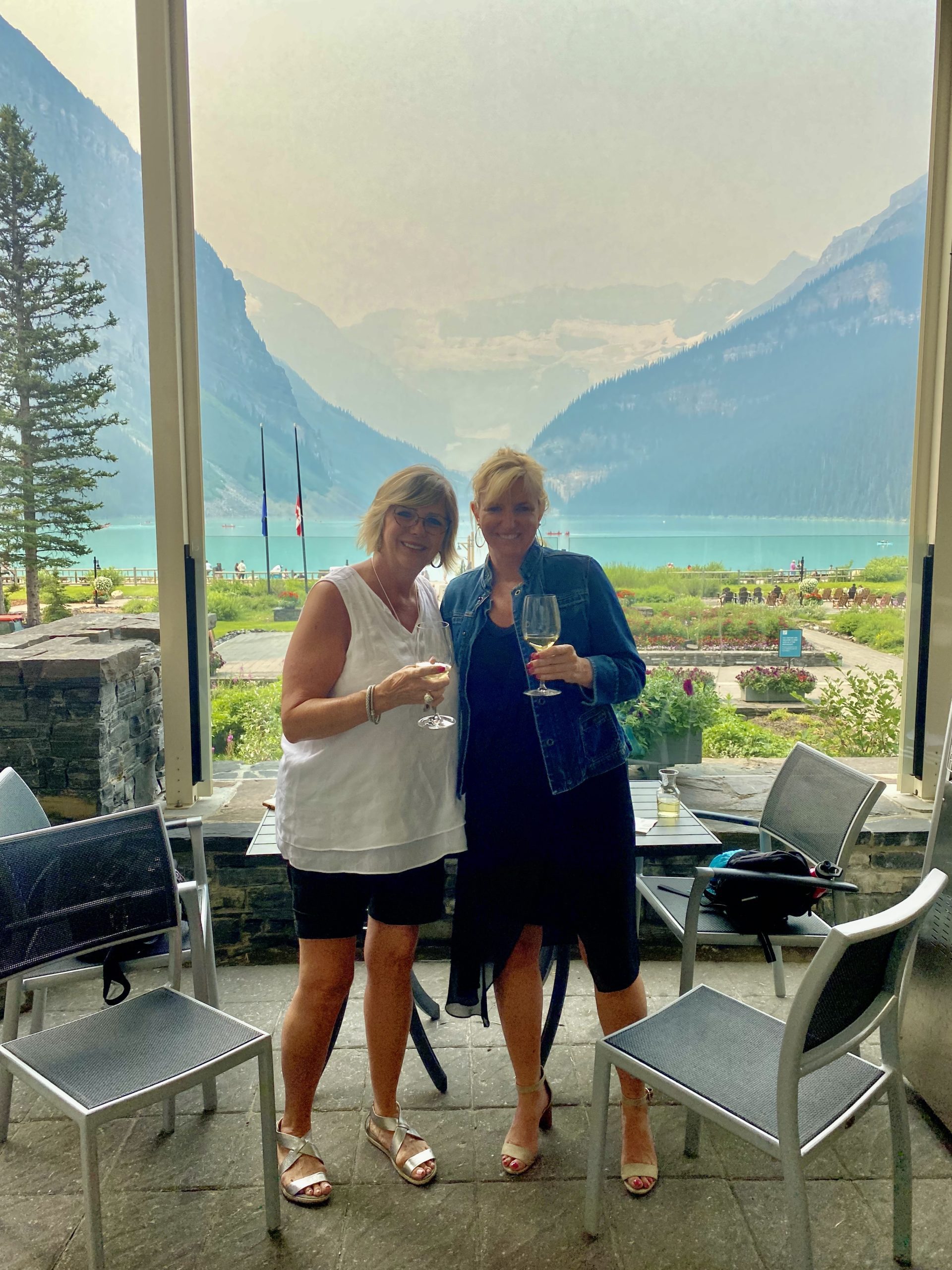 two women standing in front of a lake