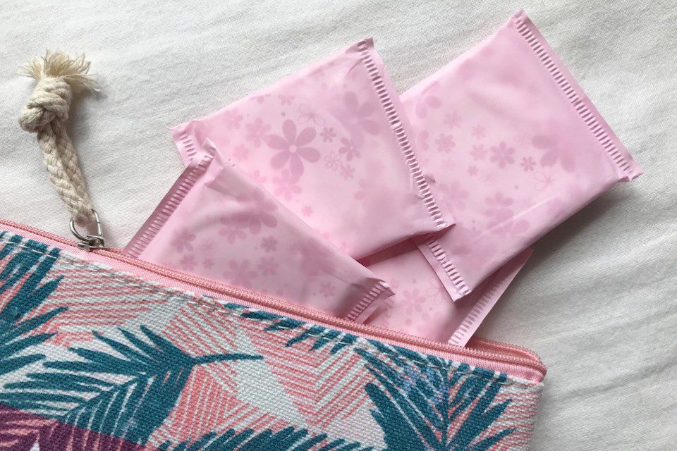 A canvas pouch with menstrual pads spilling out.