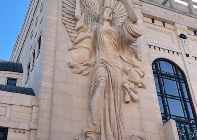 Sculpture of an angel blowing a horn carved into the side of a building