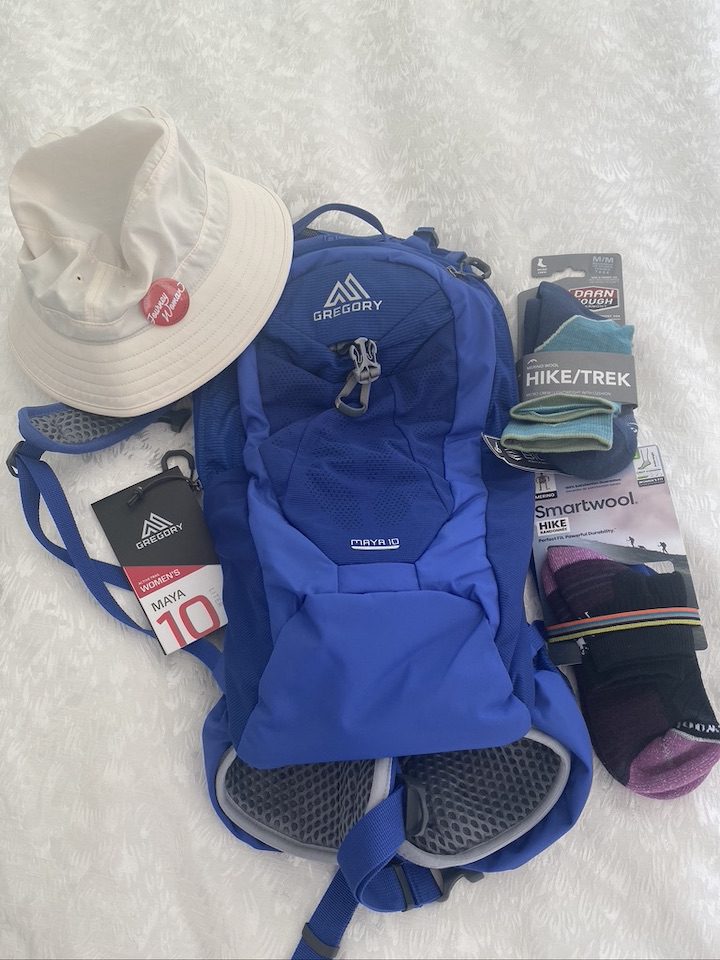 A backpack, hat, and packs of wool socks.