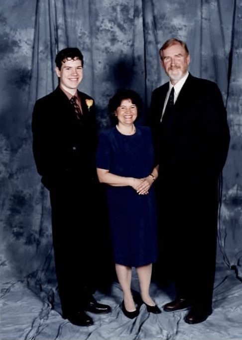 A family of three standing for a portrait