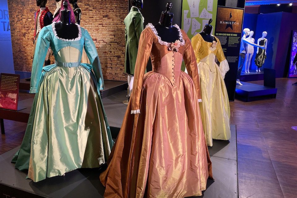 Three costumes from Hamilton on display at the Showstoppers Costume Exhibit on 42nd Street