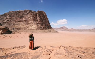 A woman standing amongst the sand in Wadi Rum Desert