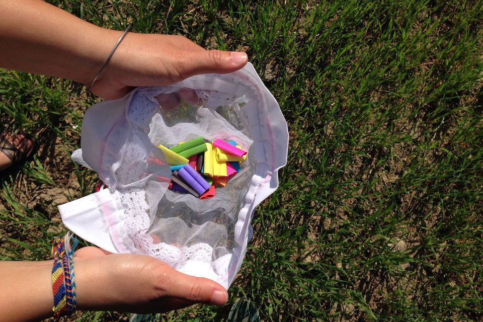 A woman opening a white bag filled with stories written on colourful paper