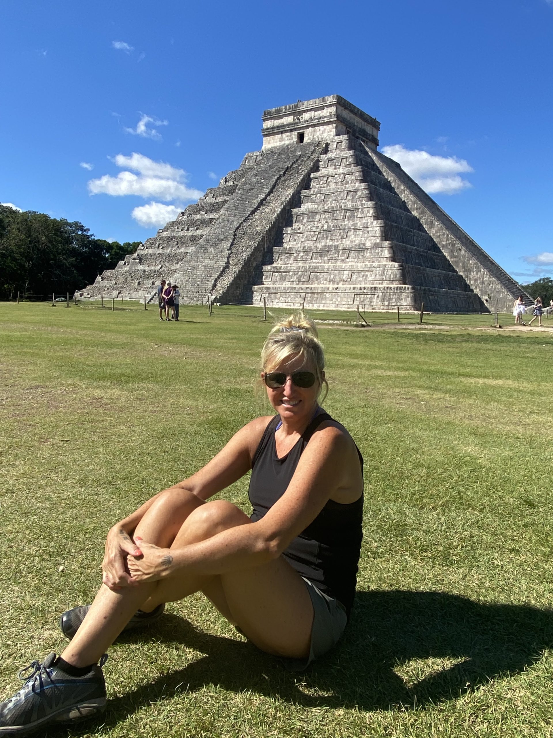 woman sitting in front of pyramid