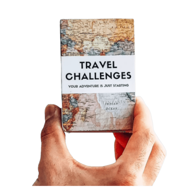 A hand holding the Travel Challenges card game