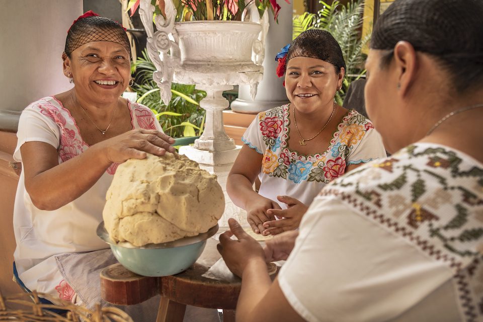 Women making Tortillas. Group of smiling cooks preparing flat bread tortillas in Yucatan, Mexico while living in Mexico