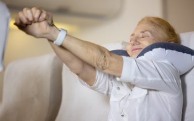 A woman over 80 stretches during a flight