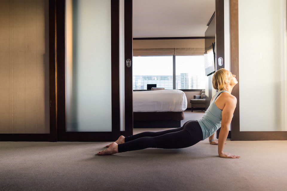 A woman practises yoga in her hotel room.