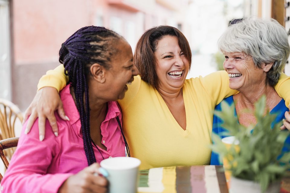 A group of older women enjoy a coffee together on their travels.
