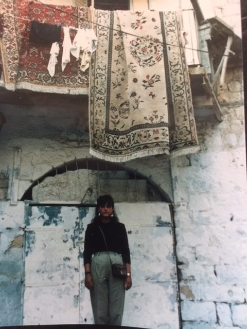 woman standing in front of a house in safed