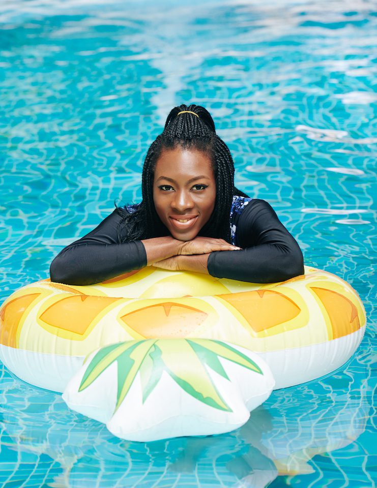 Woman in Long Sleeve Swimsuit on a floatie in a pool