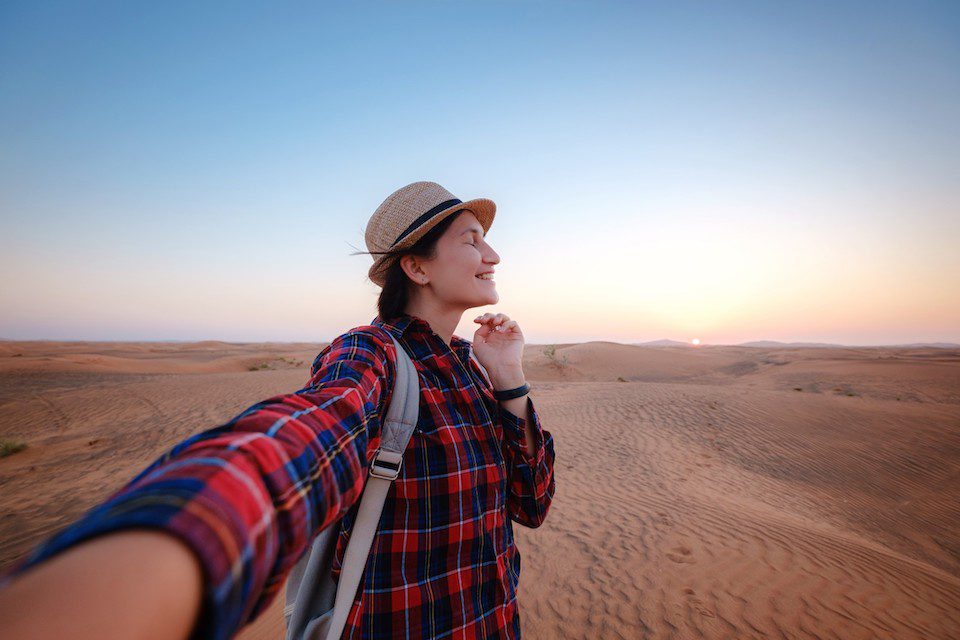 A woman takes a selfie in the Dubai desert