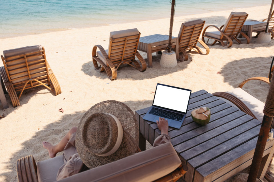 woman sitting on beach with laptop