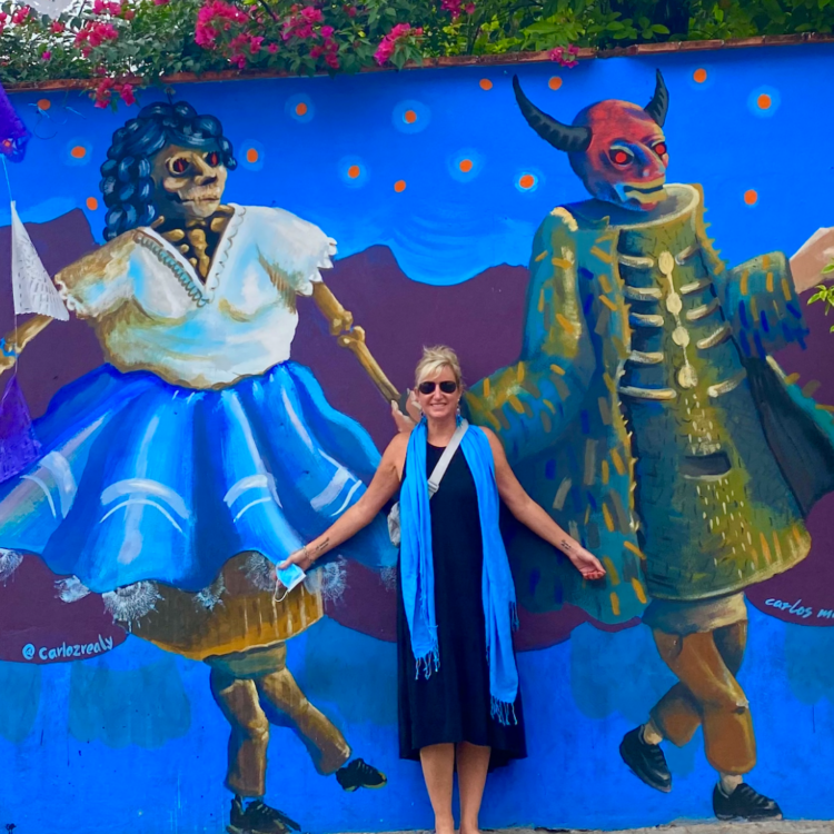 A woman stands amongst street art in Oaxaca, Mexico