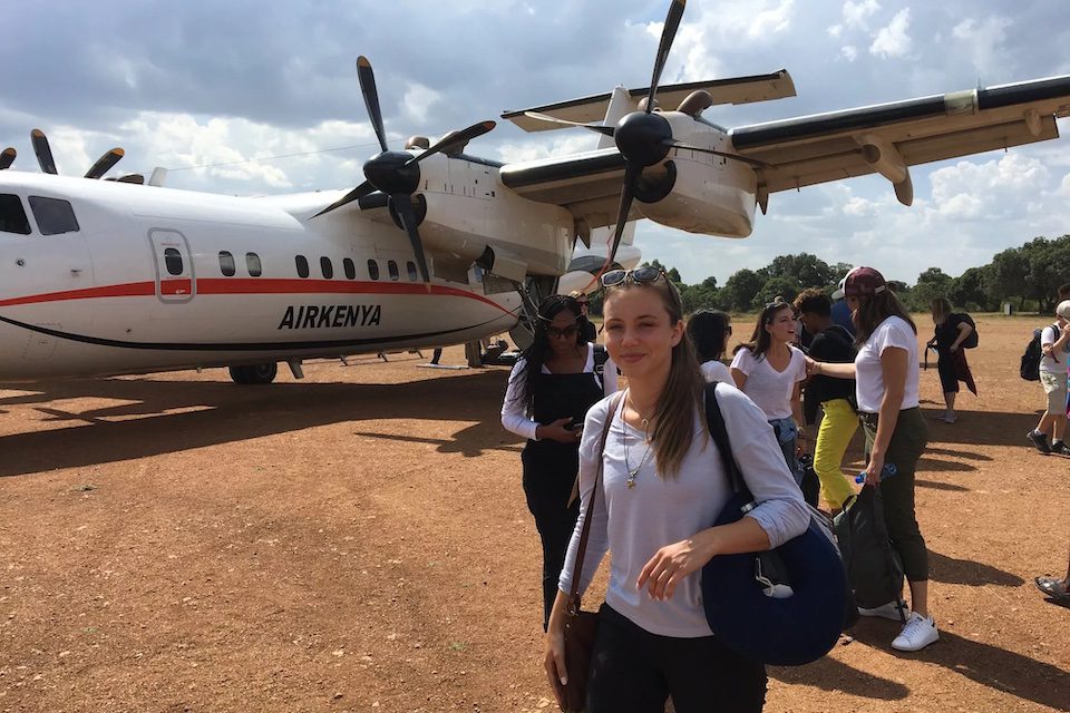 Alyx standing in front of a small plane in Kenya