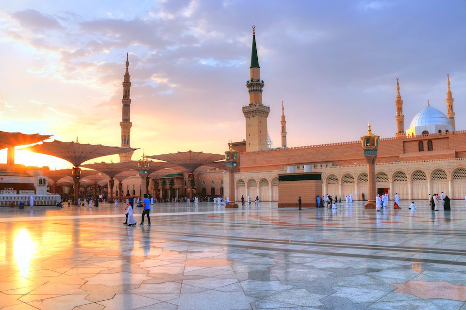 Visitors walk by Prophet Mohammed Mosque in Medina, Saudi Arabia